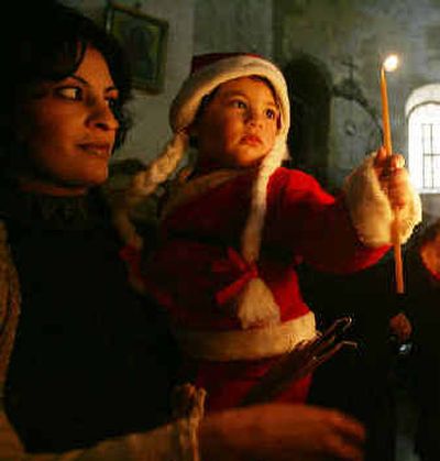A Palestinian Christian girl lights candles at the Church of the Nativity.
(Associated Press / The Spokesman-Review)
