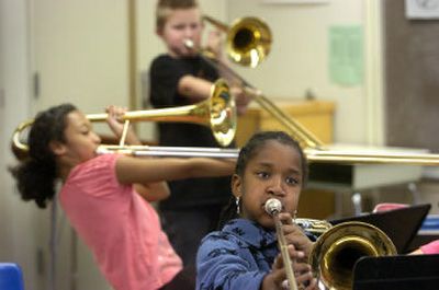 
Holmes Elementary School fifth-graders Blesseth Zeigler, front, Mahalia Johnson, left, and Nick Price, rear, blow away on their trombones Oct. 31 during music class. 
 (Dan Pelle / The Spokesman-Review)