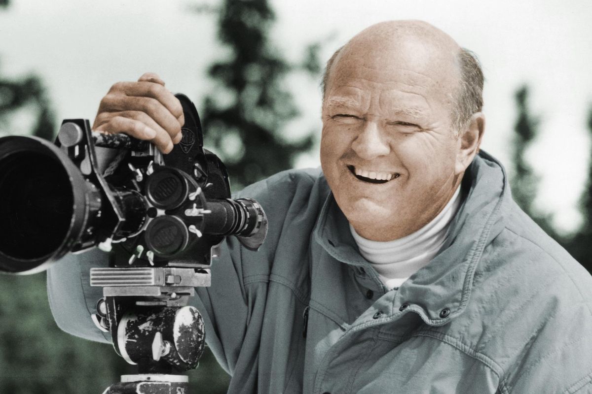 In this undated photo provided by the Warren Miller Co., Warren Miller is shown posing for a photo with a film camera. Miller, the prolific outdoor filmmaker who for decades made homages to the skiing life that he narrated with his own humorous style, died Wednesday, Jan. 24, 2018, at his home on Orcas Island, Wash., his family said. He was 93. A World War II veteran, ski racer, surfer and sailor, Miller produced more than 500 films on a variety of outdoor activities. However it was his ski films for which he was most known. (AP)