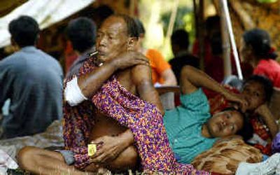
A Nicobari tribal member and others, all tsunami victims, sit at a relief camp in Port Blair, in India's southeastern Andaman and Nicobar islands, on Thursday.
 (AP / The Spokesman-Review)