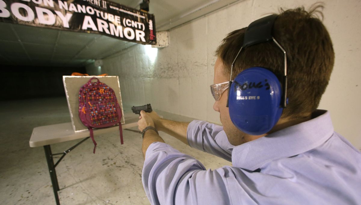 Rick Brand, Chief Operating Officer of Amendment II, shoots a 9 mm pistol into a children