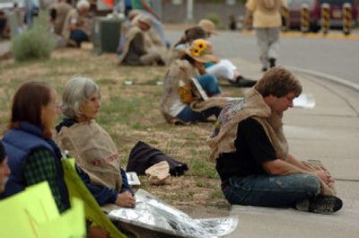 The Rev. John Dear, right, and others sit on a pile of ashes during a demonstration in Los Alamos, N.M., on Saturday on the 60th anniversary of the Hiroshima bombing. The ash symbolizes the people killed in Hiroshima during the bombing.
(Associated Press / The Spokesman-Review)