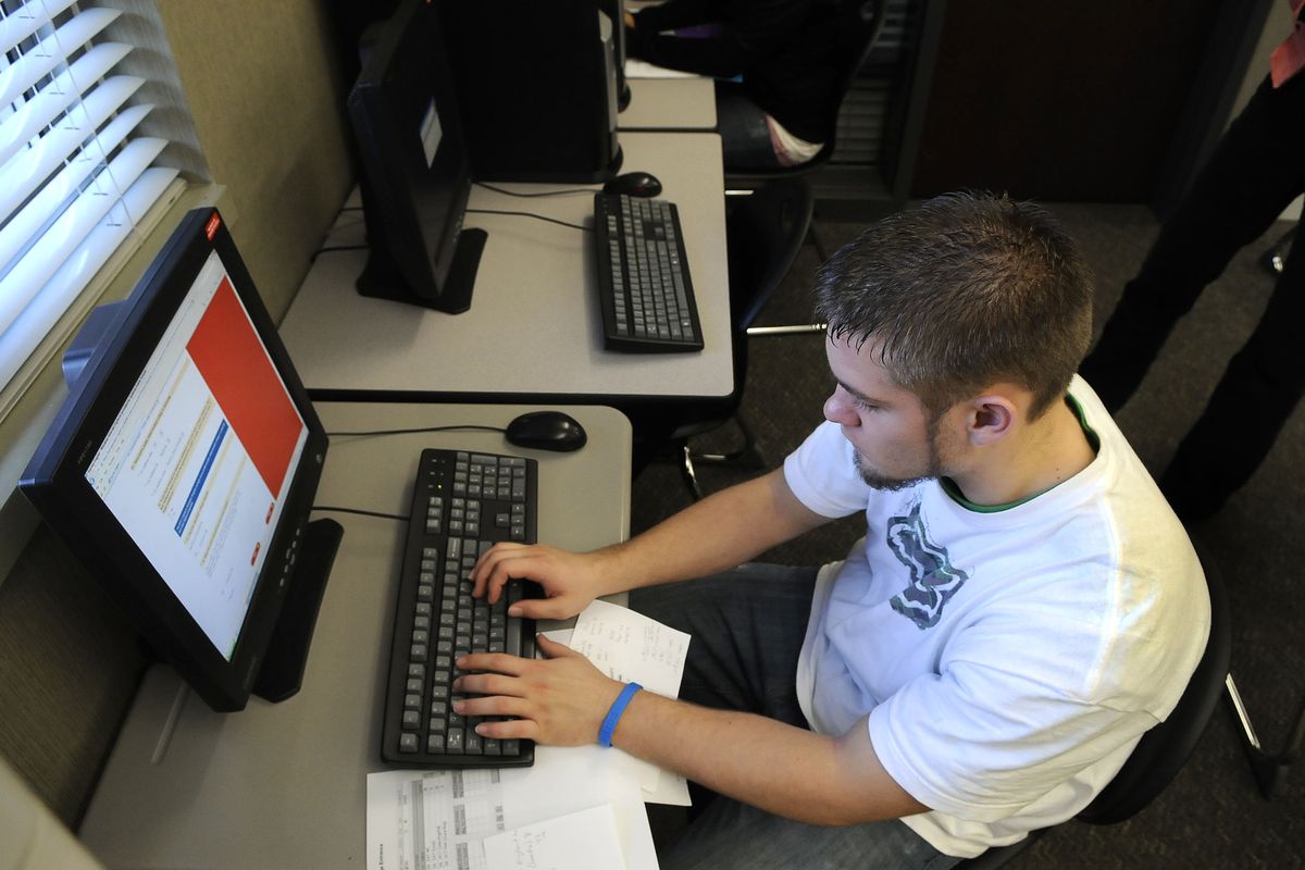 Jordan Burns, a Rogers High School senior, applies for a scholarship from KFC during a visit to the school’s career resource room. (Dan Pelle)