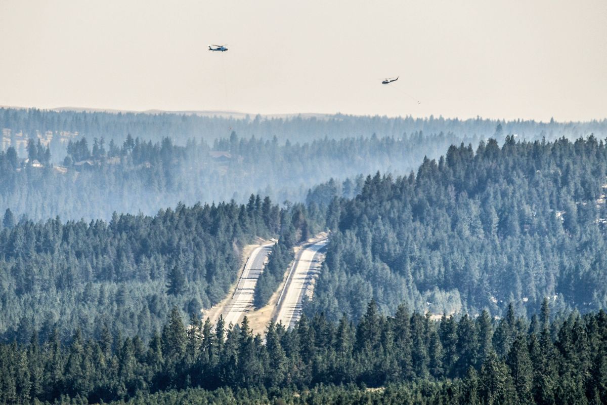 A pair of helicopters fly through smoky conditions surrounding the U.S. Highway 195 fire on Wednesday in Spokane.  (Dan Pelle/THESPOKESMAN-REVIEW)
