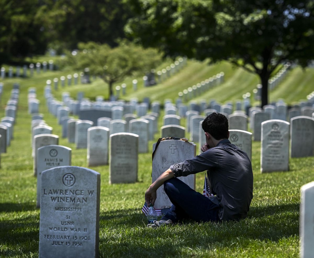 Jake Spann, 18, visits the grave of his father, CIA officer Johnny "Mike" Spann, at Arlington National Cemetery in July. Spann was the first American killed in action in Afghanistan 18 years ago. (Bill O