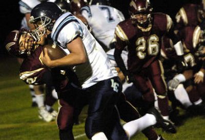 University's Joey Montes grabs the face mask of a Lake City player during Wednesday night's 29-9 non-league, season-opening loss to the visiting Timberwolves. 
 (Holly Pickett / The Spokesman-Review)