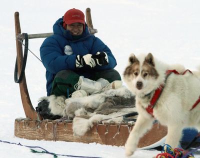 Japanese Finance Minister Naoto Kan takes a dog sled ride  on the outskirts of the northern community of Iqaluit, Nunavut, on Saturday.  (Associated Press)