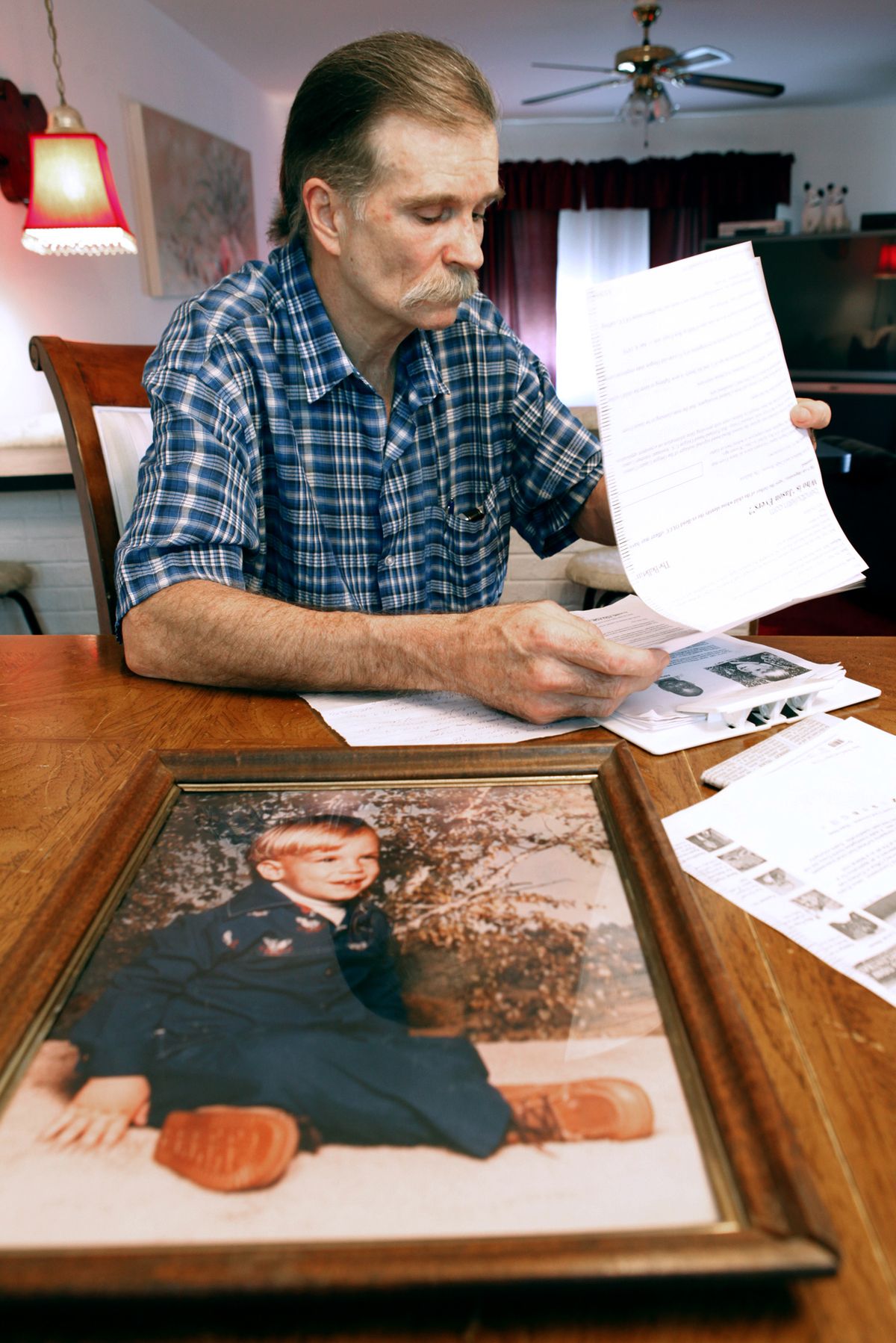 Bob Evers sits behind a photo of his son, kidnap/murder victim Jason Evers, on May 3 at his home in Harrison, Ohio.  A man who was using Jason Evers’ identity in Oregon has been identified as Doitchin Krastev, a native of Bulgaria who attended high school and college in the United States. Cincinnati Enquirer (Flenn Hartong Cincinnati Enquirer)