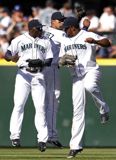 Outfielders Trayvon Robinson, left, Franklin Gutierrez and Eric Thames celebrate Mariners win over Red Sox. (Associated Press)