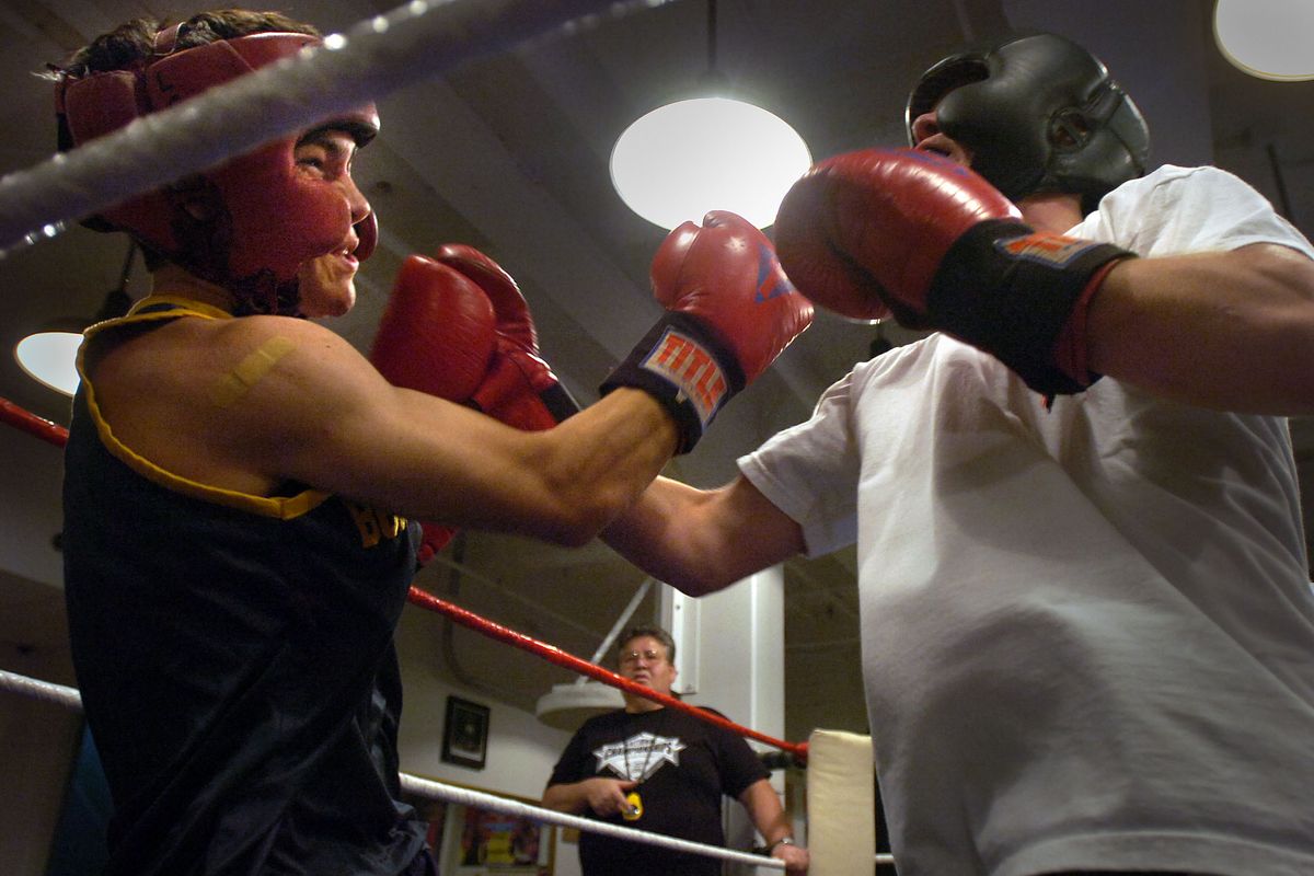 Coach Dan Vassar keeps time at the Howard Street Boxing club while Kevin Keefe, left, lands a punch to Chris Weise, during a sparring session in August of 2006.  (Jed Conklin / File/The Spokesman-Review)