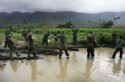 
Philippine army soldiers and U.S. Marines  build a pathway through the mud of a landslide on Sunday in Guinsaugon village in Leyte, southeast of Manila, Philippines. 
 (Associated Press / The Spokesman-Review)