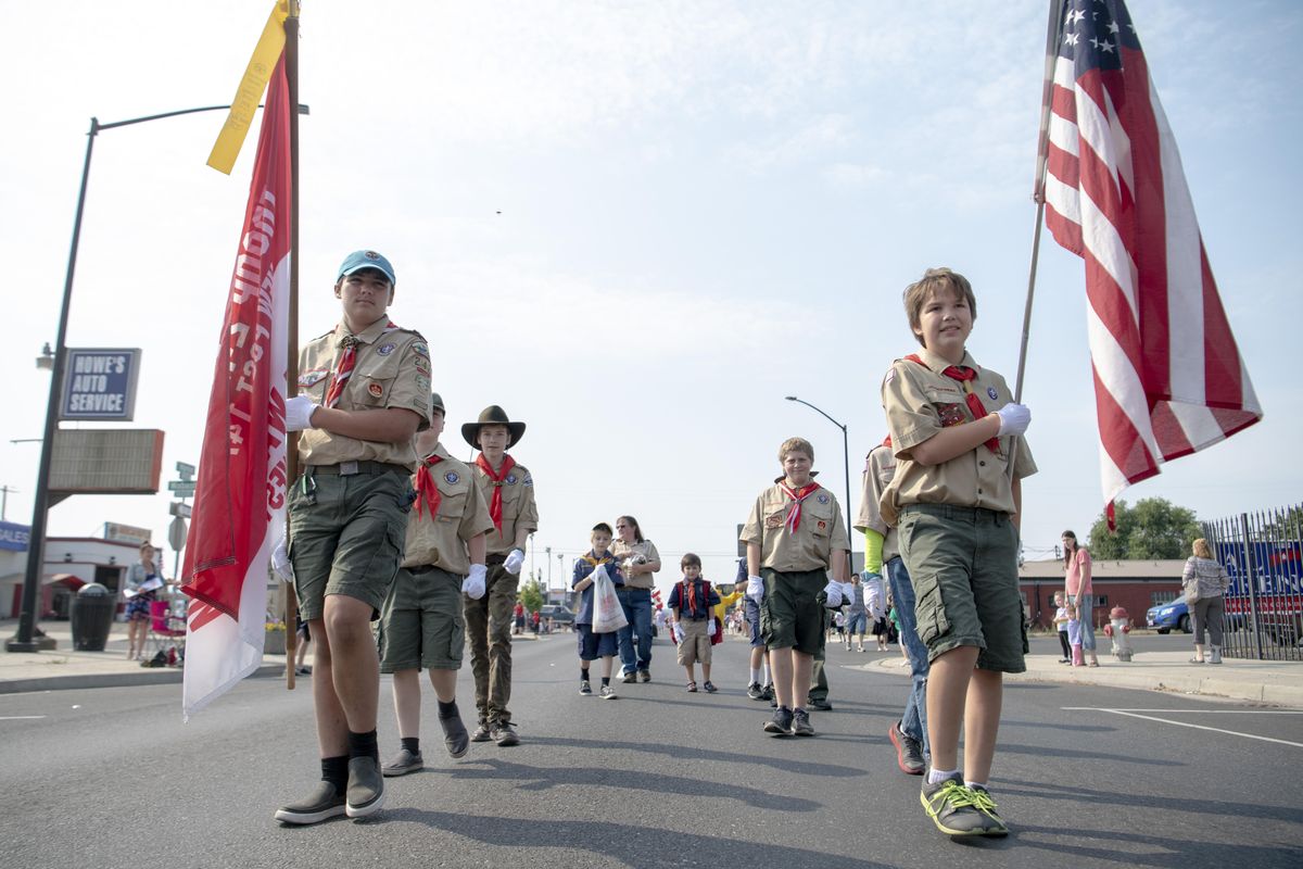 Boy Scouts Jeremiah Carr, 15, left, and Gage Vega, 12, right, carry the troop flag and the American flag Saturday, Aug. 4, 2018 in the Hillyard Hi-Jinx Parade on Market Street in Hillyard. (Jesse Tinsley / The Spokesman-Review)