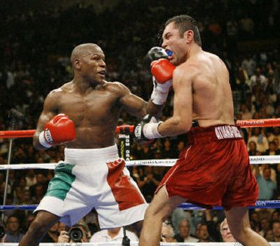 
Many fans would like to see Oscar De La Hoya, right, get another shot at Floyd Mayweather after last weekend's split decision. 
 (Associated Press / The Spokesman-Review)