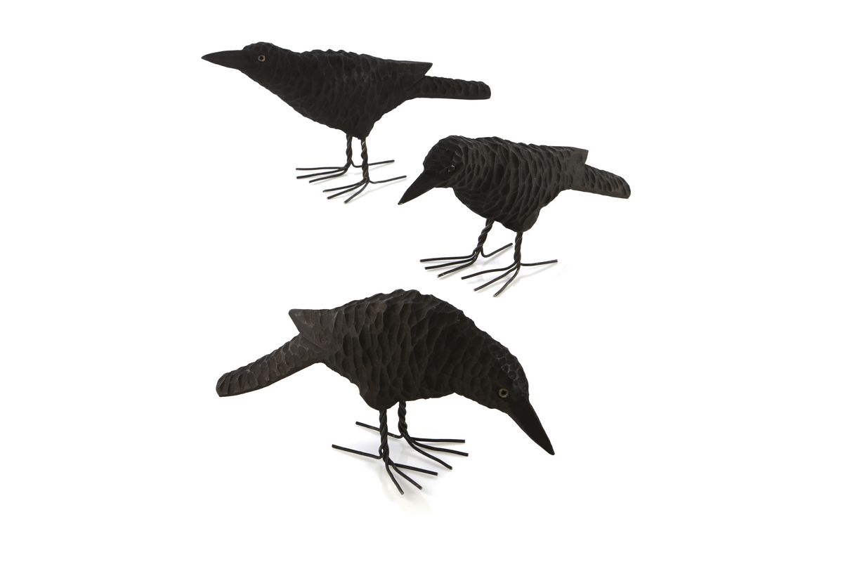Carved wooden ravens from Crate & Barrel can be situated throughout the room to add Halloween drama. (Associated Press)