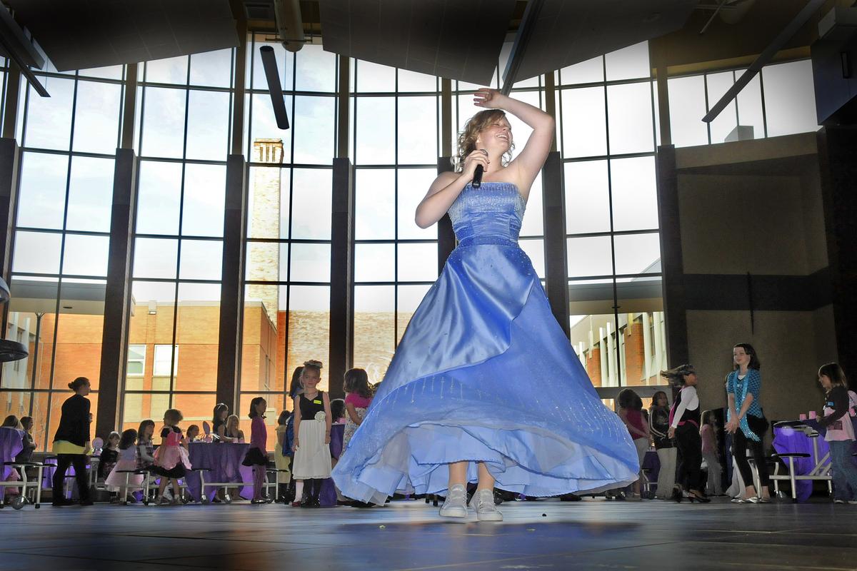 Kaysha Lybecker dances and spins as she warms up a crowd of young girls with some games Saturday, Nov. 20, 2010. Lybecker and her Rogers High School friends put on their prom dresses and turned the school commons area into a giant princess tea party. (Christopher Anderson / The Spokesman-Review)