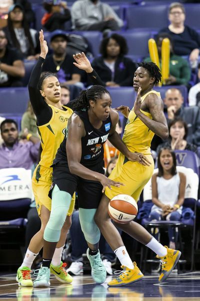 New York Liberty center Tina Charles drives through Seattle Storm forwards Alysha Clark, left, and Natasha Howard to make a shot with about a minute left in a WNBA basketball game Wednesday. July 3, 2019. (Bettina Hansen / Seattle Times via AP)