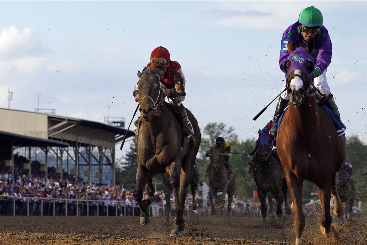 California Chrome, right, ridden by jockey Victor Espinoza, wins the 139th Preakness Stakes horse race at Pimlico Race Course, Saturday, May 17, 2014, in Baltimore. At left is Ride on Curlin who finished second.  (Matt Slocum / Associated Press)