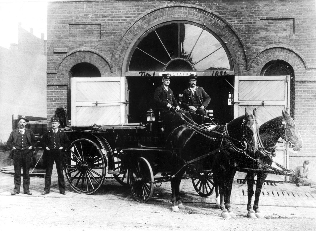 The firefighters of Spokane Station No. 1 pose with their horse-drawn wagon outside the building in 1890. The station started using automobiles in 1911.  (Photo archive / The Spokesman-Review)