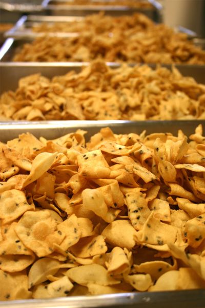 Fried senbei crackers wait to be coated with a salty, sweet soy-ginger mixture at Highland Park United Methodist Church. Church members make the popular rice crackers for the bake sale at the sukiyaki dinner during Japan Week. (Lorie Hutson)