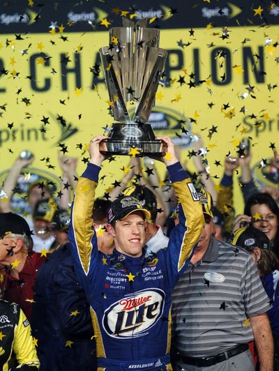 Brad Keselowski holds trophy aloft after winning the NASCAR Sprint Cup Series championship. (Associated Press)