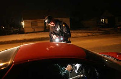 
WSP Trooper Barry Marcus checks the license of a drunken-driving suspect in February. Spokane County handles over 1,000 DUI cases a year. 
 (Rajah Bose / The Spokesman-Review)
