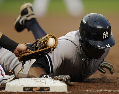 The Yankees’ Curtis Granderson dives safely back to first base on a pickoff attempt against the Orioles last August. (Associated Press)