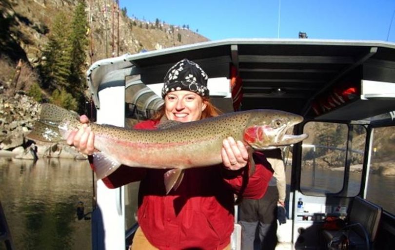 Amy Sinclair of Exodus Wilderness Adventures in Riggins hoists a Salmon River steelhead aboard her jet boat. (Exodus Wilderness Adventures)