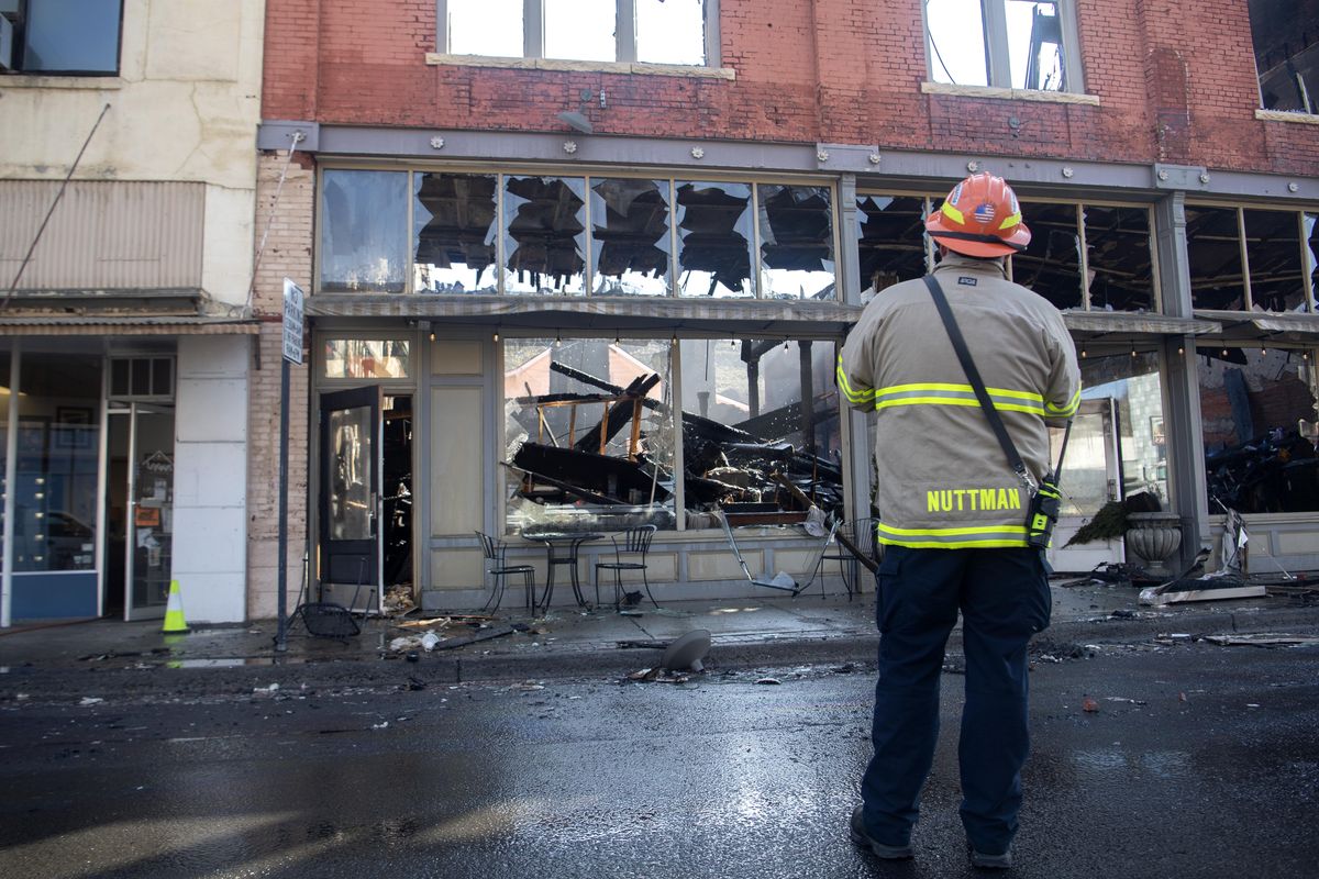 Fire investigator Tony Nuttman looks over the scene Wednesday, Mar. 18, 2020 after a fire gutted a historic downtown building in Colfax Tuesday night. The fire destroyed the Fonk’s Cafe bulding, which also also housed the sports apparel company also owned by the cafe owners. (Jesse Tinsley / The Spokesman-Review)