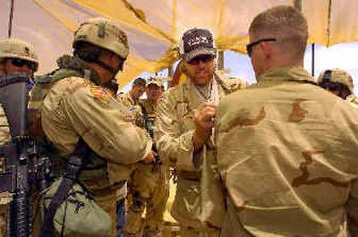 
In this photo provided by the USO, country music star Toby Keith signs his autograph on the camouflage uniform of a U.S. soldier after a United Service Organizations performance at Forward Operating Base Danger, near Tikrit, Iraq for U.S. troops last week. 
 (Associated Press / The Spokesman-Review)