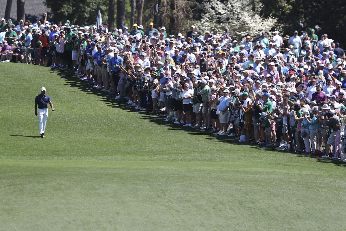 The giant gallery of patrons following five-time Masters champion Tiger Woods applaude as he walks down the first fairway after teeing off to begin his practice round for the Masters at Augusta National Golf Club in Augusta, Ga., Monday, April 4, 2022.  (Associated Press)