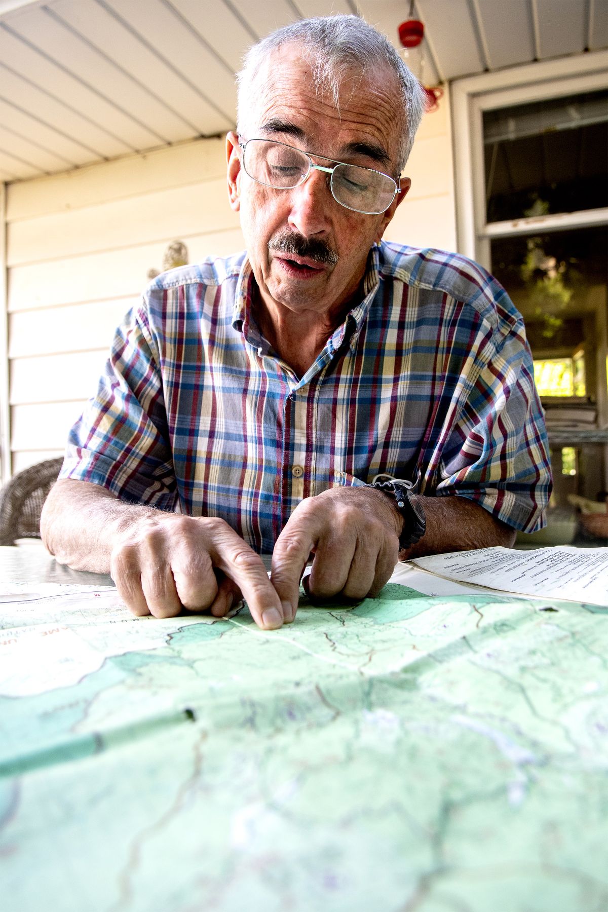 David Wolfe looks over a map, pointing out the area he was hiking in and where he got turned around, at his home in Kooskia last week.  (August Frank/Lewiston Tribune)