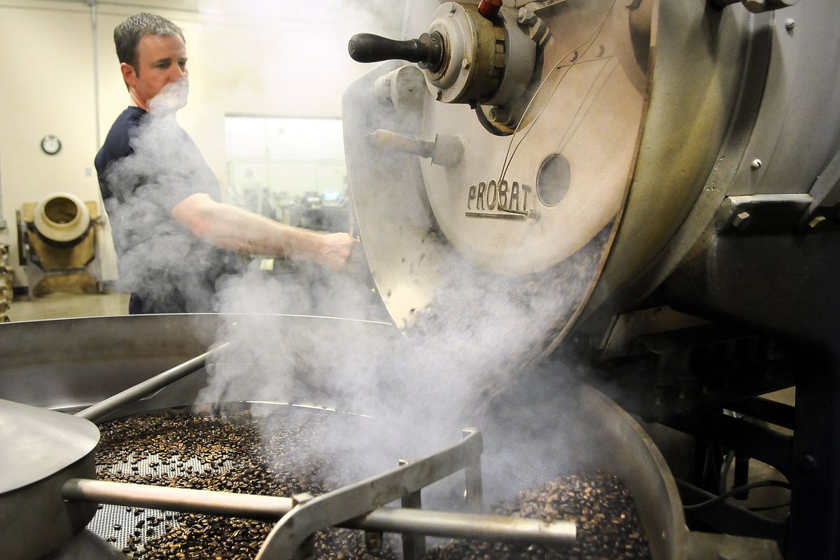 Steve Matott, head coffee roaster at Cravens Coffee Co., empties a batch of Italian roast coffee beans into the cooling tray at offices in Spokane. (Dan Pelle)