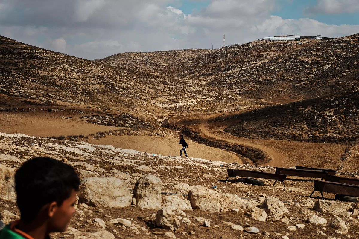 Palestinian children in Wadi Tiran roam hilly farmlands with a view of an Israeli settlement that was built in recent years.  (Marcus Yam)