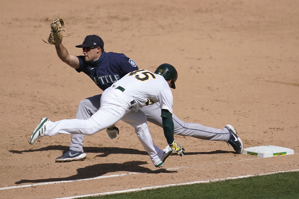 Seattle Mariners’ Evan White, left, forces out Oakland Athletics’ Nate Orf at first base during the sixth inning of a baseball game in Oakland, Calif., Sunday, Sept. 27, 2020.  (Jeff Chiu)