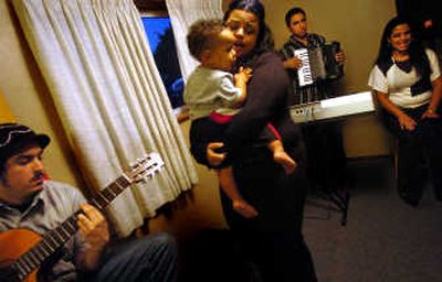 
Christina Vigil dances with her nephew, Cortez Coleman, during a Los Vigiles practice session. Christina, a vocalist, is joined by her father and two brothers in the group that performs rhumba- and flamenco-style tunes. Los Vigiles are two generations of family that have been playing together since 1999. 
 (Photos by INGRID BARRENTINE / The Spokesman-Review)