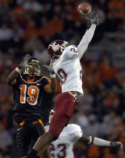 
WSU's B.J. Williams leaps high to bat down a pass intended for OSU's Sammie Stroughter. 
 (Christopher Anderson / The Spokesman-Review)