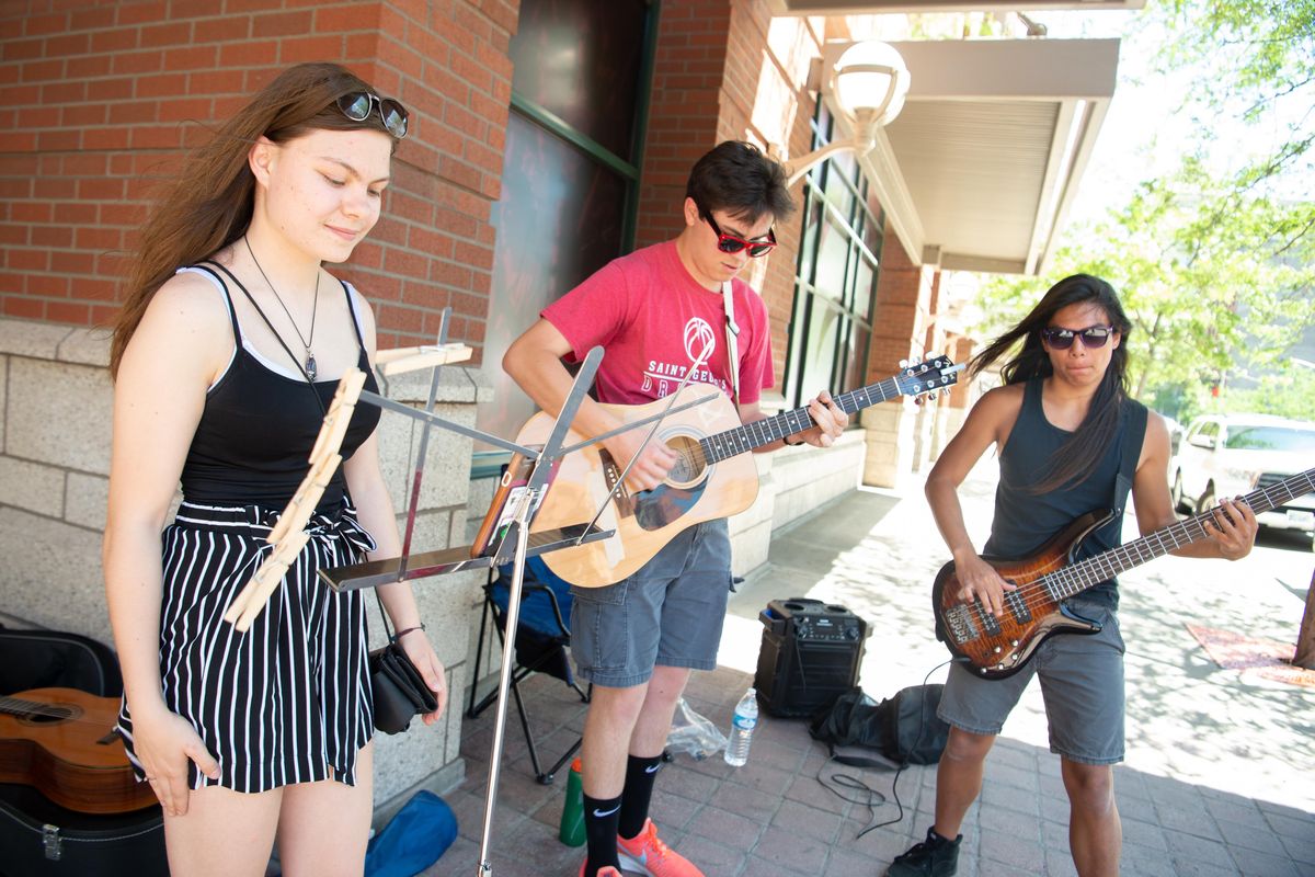 Alex Gustafson, left, Ben Clark, and Alex Anderson play a rock song on the corner of Riverside Avenue and Wall Street in downtown Spokane Thursday, June 13, 2019. It was the first participation in Street Music Week for the three students of St. George’s School in North Spokane. (Jesse Tinsley / The Spokesman-Review)