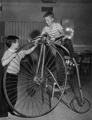 Randy (left) and Bruce Dill, sons of Mrs. Dorothy Dill, 1216 W. College, try out an Overman racing bicycle on display at the Cheney Cowles museum, 2316 W. First, Nov. 6, 1960. The bike, built in 1886 in New England and sold new for $135, was typical of the type used in the 1880s.     (Photo Review / The Spokesman Review)