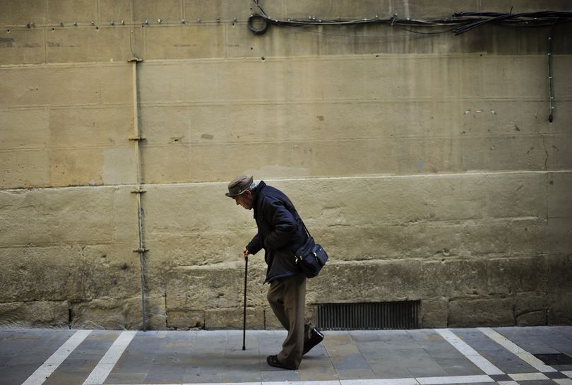 An elderly man goes for a walk aided by a walking-stick, in Pamplona northern Spain on Wednesday, May 22, 2013. (Alvaro Barrientos / Associated Press)