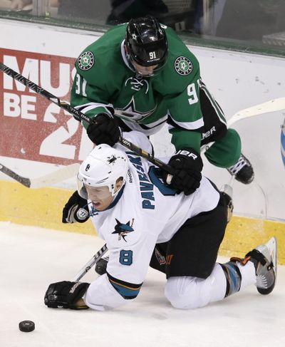 Dallas’ Tyler Seguin (91) and San Jose’s Joe Pavelski play a little leapfrog competing for a loose puck in Stars’ 4-3 shootout win. (Associated Press)