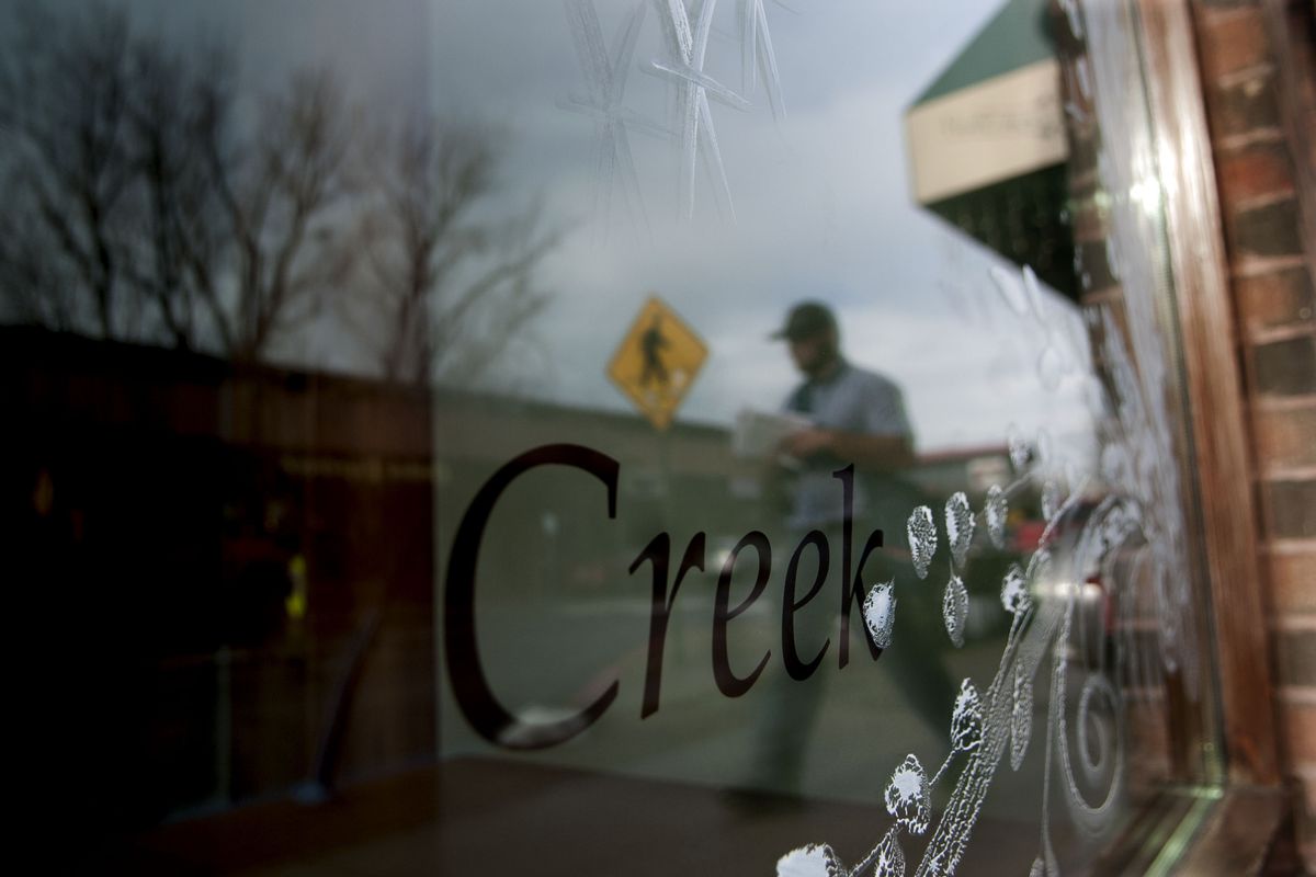 A mail carrier walks past the former Coldwater Creek storefront along First Avenue in Sandpoint on Dec. 10. (Kathy Plonka)