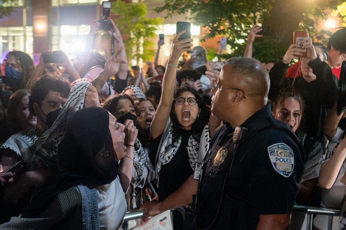Protesters lock arms after breaking through barricades to enter the University Yard encampment at George Washington University in Washington on Sunday. 