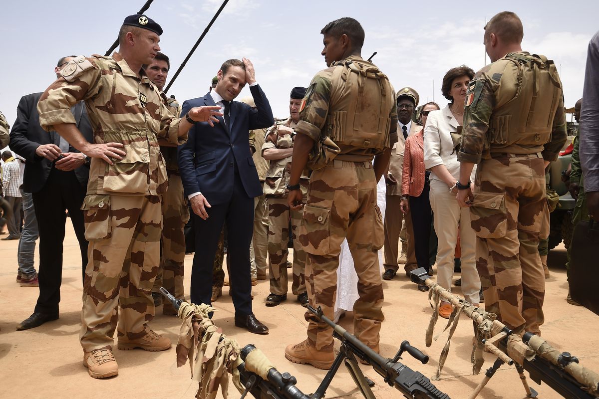 FILE - In this May 19, 2017 file photo, French President Emmanuel Macron, center left, visits soldiers of Operation Barkhane, France
