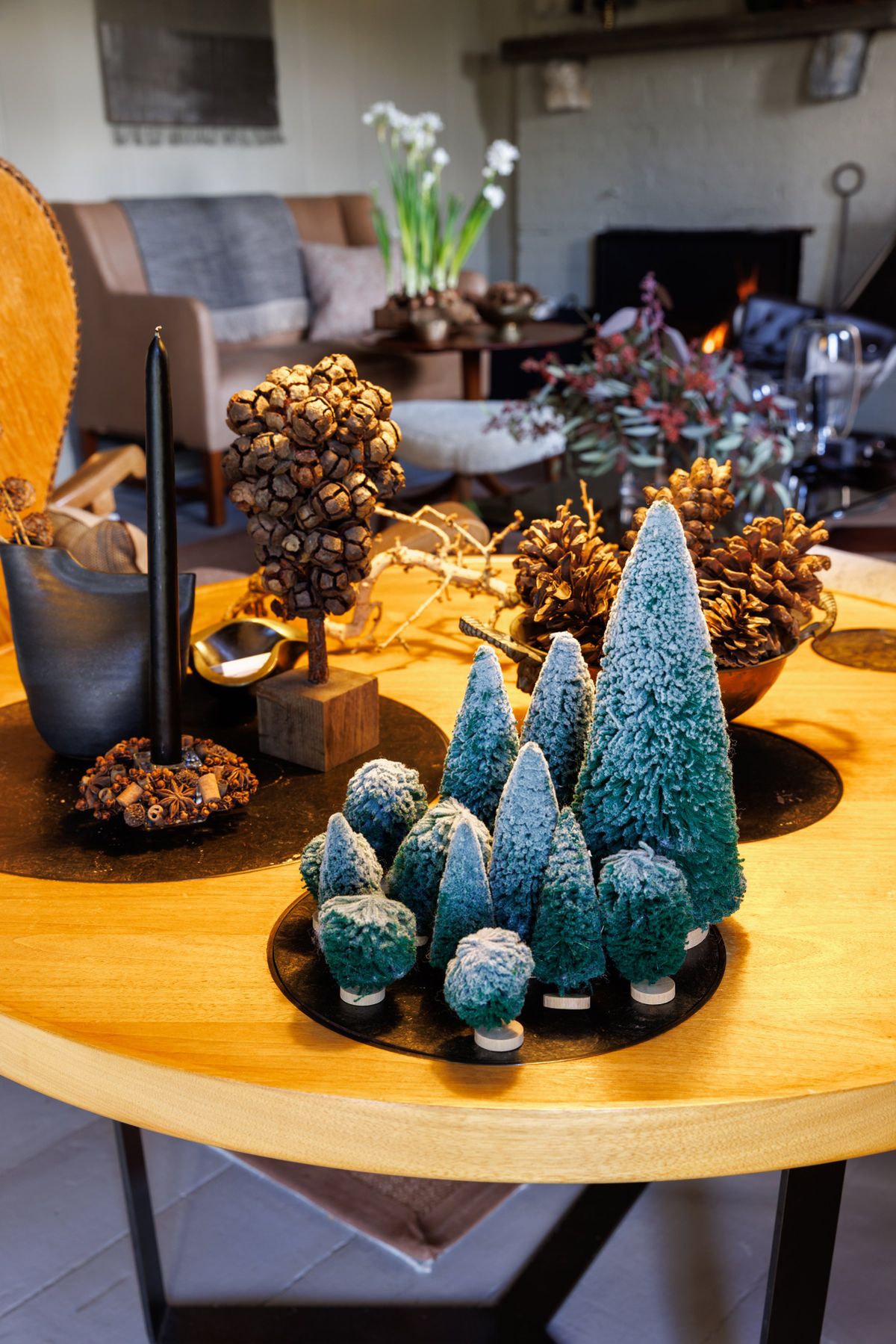 Pine cones and seedpods are used in the holiday decor in Shawn Henderson’s sitting room at his home in Hillsdale, N.Y., Nov. 24, 2025. The designer Shawn Henderson leans into simple greens and vintage lights for his home. (Stefano Ukmar/The New York Times) (STEFANO UKMAR)