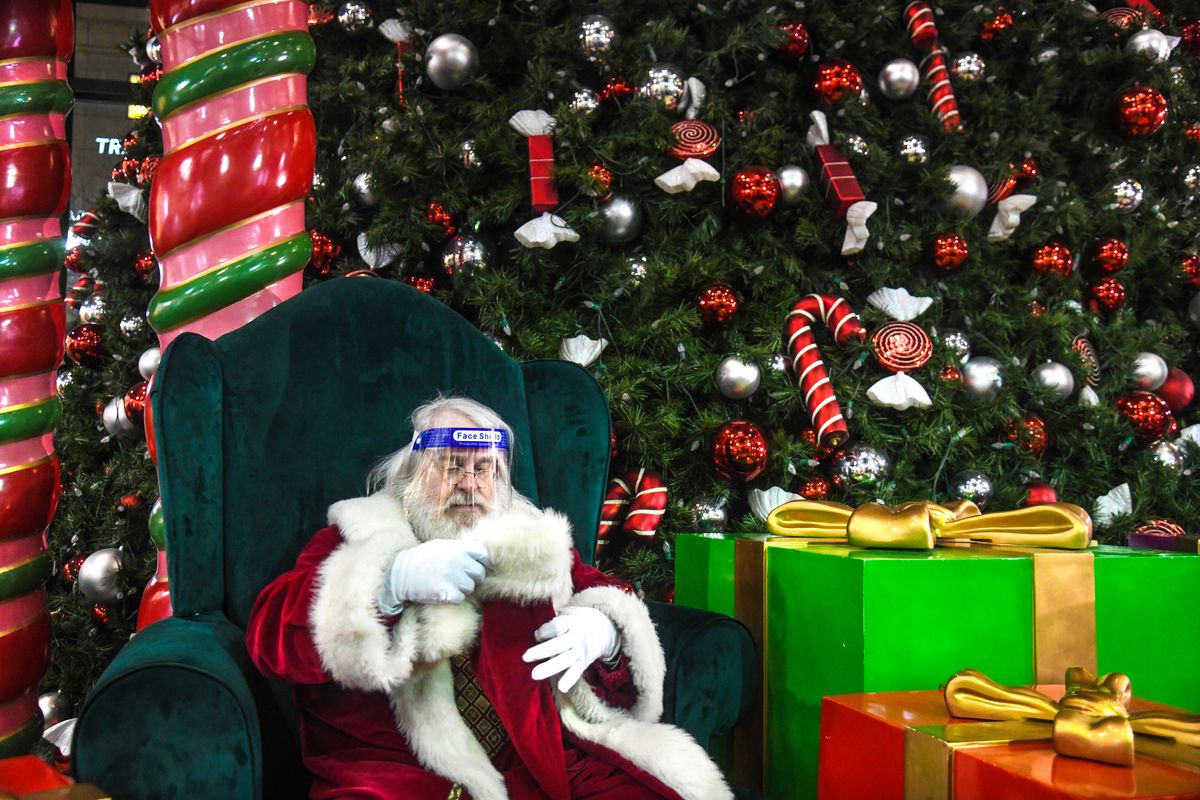 Santa Claus, also known as Jim Burney, tries on a face shield before making an appearance for the lighting of the tree, Friday evening, Nov. 20, 2020, at River Park Square.   (DAN PELLE/THE SPOKESMAN-REVIEW)