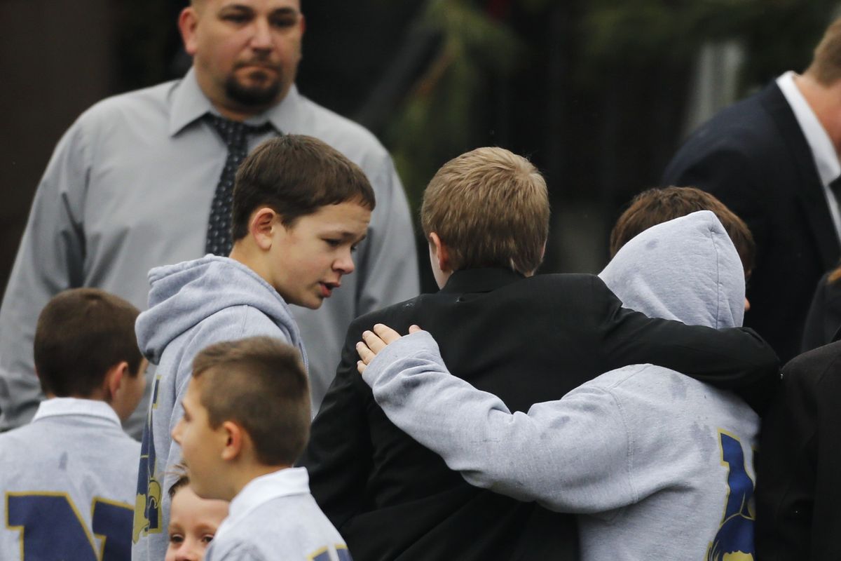 Studens embrace while wearing Newtown school shirts outside the funeral for six-year-old student shooting victim Jack Pinto in Newtown, Conn., Monday, Dec. 17, 2012. A gunman opened fire at Sandy Hook Elementary School in the town on Friday, killing 26 people, including 20 children before killing himself. (Charles Krupa / Associated Press)
