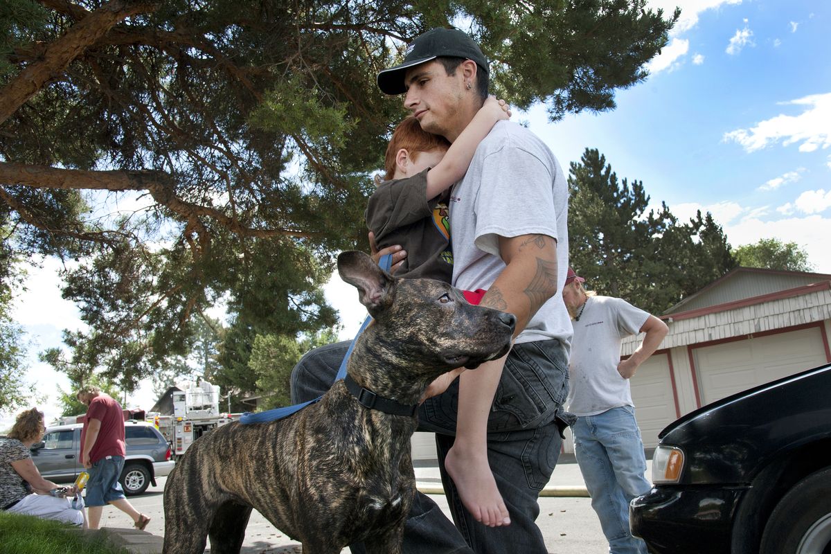 Steven Peters has a hug for his son Anthony, 4, after a fire swept through their unit at the Broadway Square Apartments in Spokane Valley on Monday. Their dog, Bonita, alerted the boy and his mother, Tara Peters, to the blaze. (Dan Pelle)