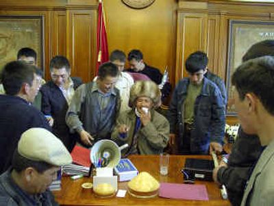 
Kyrgyz opposition supporters gather Thursday in President Askar Akayev's office in Bishkek, Kyrgyzstan. An opposition leader, Ulan Shambetov, sits in Akayev's chair. 
 (Associated Press / The Spokesman-Review)