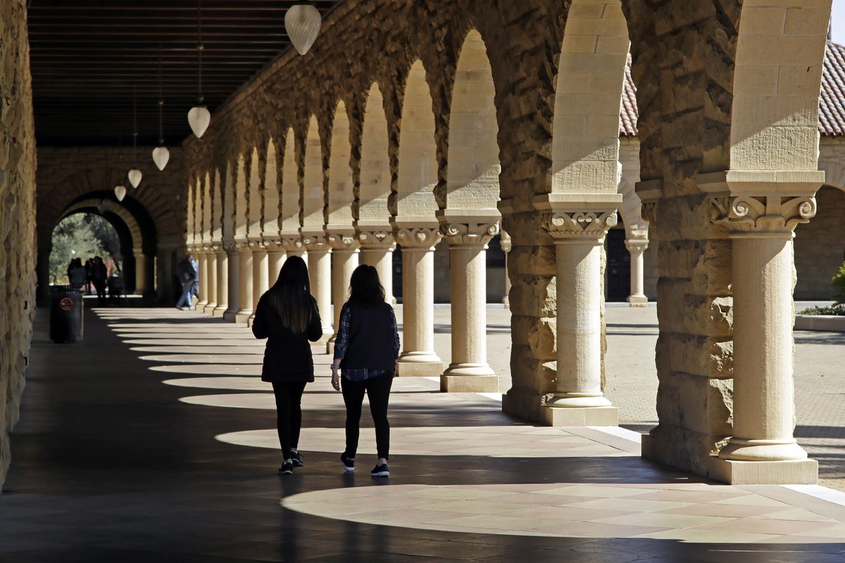 FILE — Students walk on the Stanford University campus in Stanford, Calif, March 14, 2019. When students at Stanford University return to campus in January 2022, they