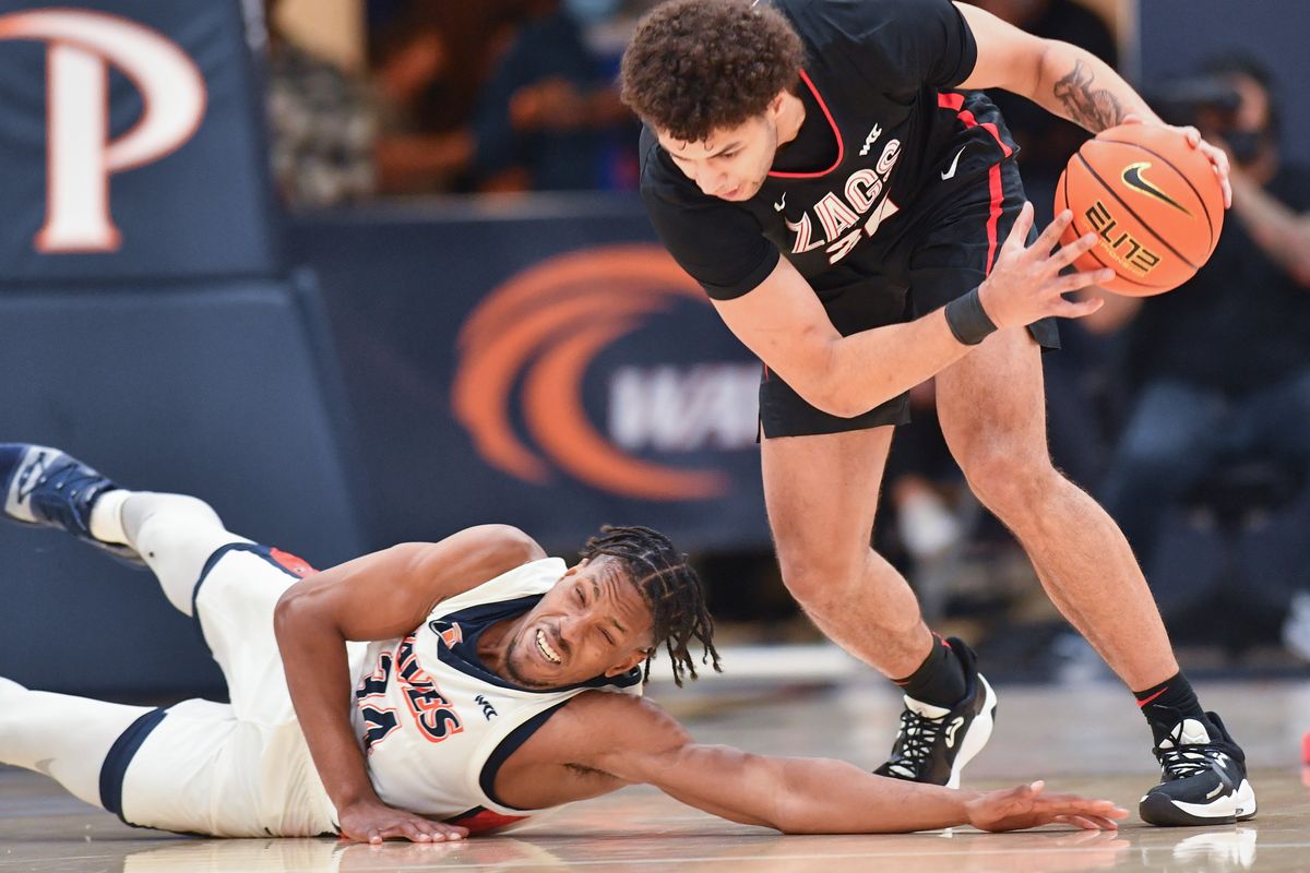 Pepperdine Waves center Victor Ohia Obioha (34) reacts as he hits the floor chasing a loose ball as Gonzaga Bulldogs forward Anton Watson (22) picks it up during the first half of a college basketball game on Wednesday, Feb 16, 2022, at Firestone Fieldhouse in Malibu, Calif.  (Tyler Tjomsland/The Spokesman-Review)